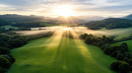 Breathtaking sunrise illuminates misty countryside, casting golden rays over lush green fields