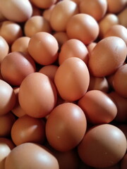Closeup shot of a pile of fresh brown eggs