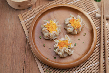 Dumplings on wooden plate and wooden table