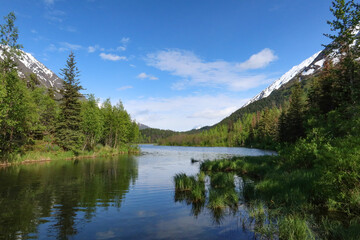 Blue sky and fluffy clouds over Alaska's Tern Lake on a sunny summer day.
