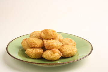 Potato fritter on green plate on white background