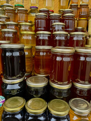 Honey store counter top full of types of honey jars in different colors with copy space for mockup