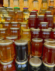 Honey store counter top full of types of honey jars in different colors with copy space for mockup