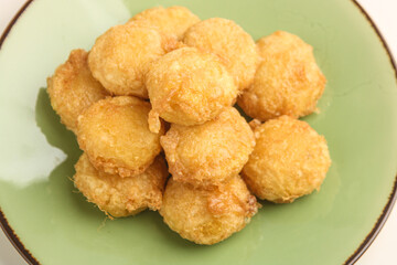 Potato fritter on green plate on white background