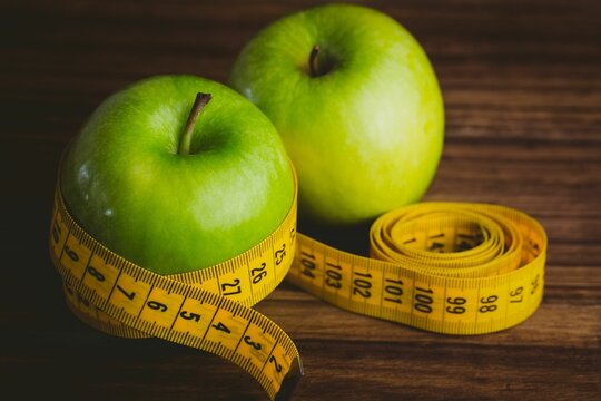 Fototapeta Green apples and measuring tape