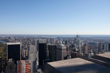 Flat design skyline is showing stone railing viewpoint, glass skyscrapers, distant river, city grid © vectorfusionart
