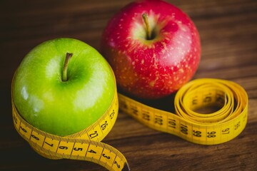Red and green apples with measuring tape
