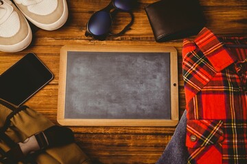 Flat design showing chalkboard with sneakers, sunglasses, wallet, phone and other items on desk