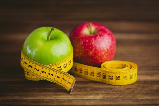 Fototapeta Red and green apples with measuring tape