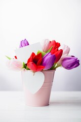 Flat illustration tulip bouquet is being placed in pink bucket with white card and heart tag