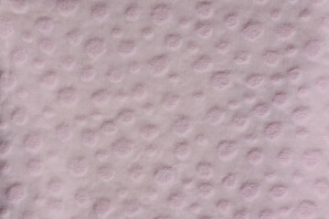 Light pink fabric with textured circular dots close-up abstract background
