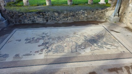 Pompeii, Italy - 8 January 2025. A restored Alexander Mosaic in the House of the Faun shows Alexander the Great battling Persians, with vivid figures, horses, and spears in dynamic mid-action.