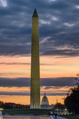The illuminated Washington Monument before sunrise with the Capitol Building in the back