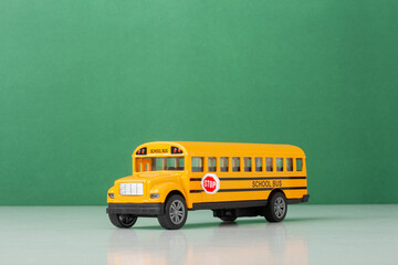 Yellow School Bus Against Solid Green chalkboard Background, back to school concept