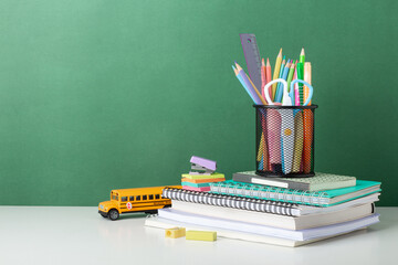 Colorful School Supplies Arranged on Desk With Green Background