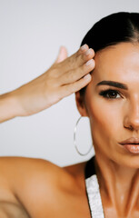 Naklejka premium Woman showcasing beauty and style through elegant pose and makeup in indoor setting