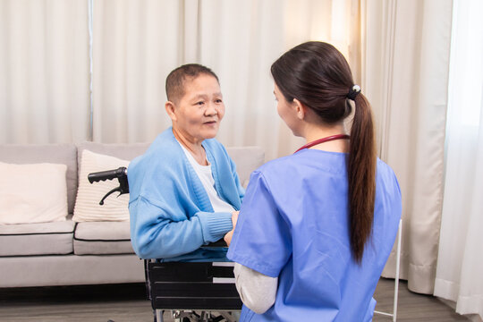 Young nurse and senior woman seated face to face, holding hands, engaging in compassionate conversation, showing attentive care and patient-centered communication at home, healthcare. - Powered by Adobe