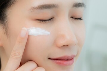Beautiful Asian woman smile use cream for good skin. face of a healthy woman apply cream and...