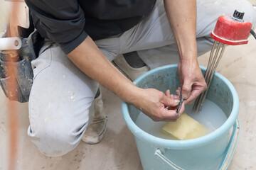 カッターに付いた糊を落とすクロス職人

