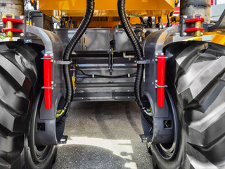 Close-up view of heavy machinery tires and hydraulic systems on a construction vehicle at a worksite