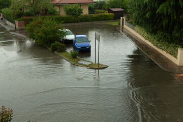 Flooded street with parked cars after heavy rain