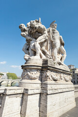 Obraz premium Marble sculpture group on the Ponte Vittorio Emanuele II in Rome, Italy, depicting warrior figures against a clear blue sky