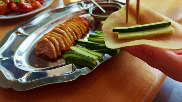 Using Chopsticks To Place Sliced Peking Duck On Pancake.  Roasted Duck Meat With Crispy Skin And Cucumber