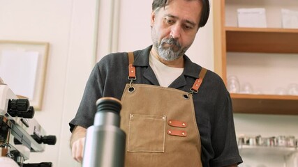 Senior entrepreneur prepares coffee with steady hands, dressed in apron. cafe professtional bar reflects a small business owner identity hard work, skill, freedom retired occupation working lifestyle