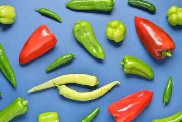Different fresh peppers on blue background