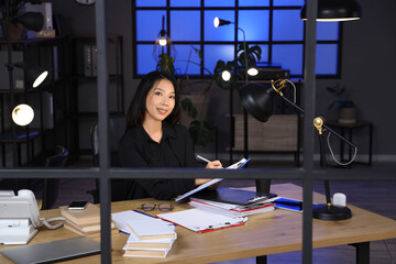 Happy Asian businesswoman working in office at late evening