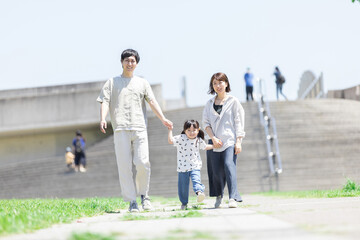 手を繋いで屋外を散歩する親子