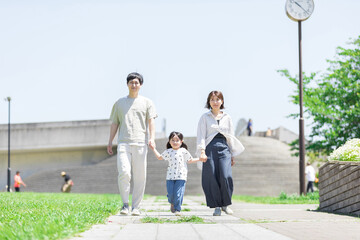 手を繋いで屋外を散歩する親子