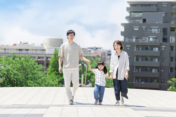 手を繋いで屋外を散歩する親子