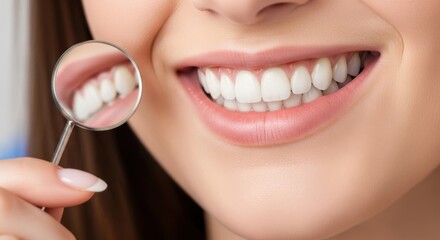 Fototapeta premium Closeup of a woman s healthy white teeth reflected in a dental mirror