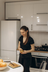 Smiling Woman Preparing a Meal in a Bright Modern Kitchen Setting