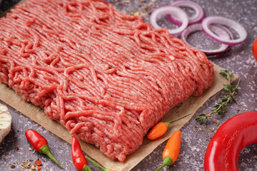 Fresh minced meat with spices on grey background