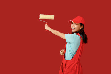 Female Asian painter with roller on red background
