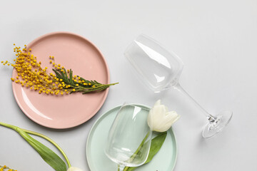 Beautiful table setting with mimosa flowers and white tulips on grey background