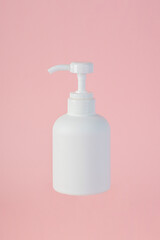 The medium-sized white bottle is a pump bottle for cream with a pink background.