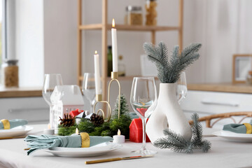 Beautiful festive table setting for Christmas celebration with wreath and candles in dining room