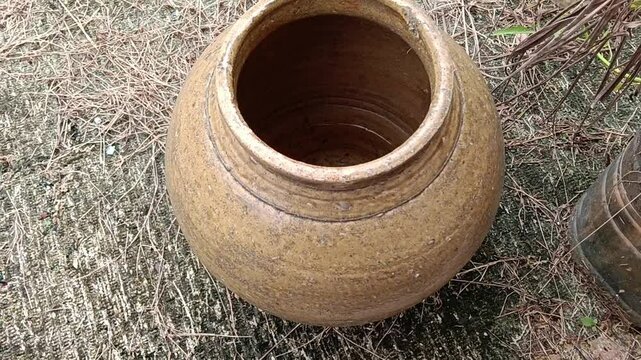 Old clay pot on the ground in the garden at kluang, johore, malaysia