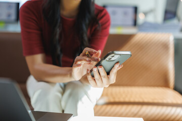 Office worker using mobile phone and laptop in the workplace