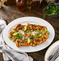 Grilled fish assortment with herbs in bright rustic overhead composition on wooden table