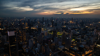Obraz premium Night view of Bangkok with glowing skyscrapers and vibrant city lights showcasing a bustling urban scene. Bangkok, Thailand.