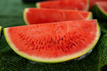Closeup of a slice of red watermelon on the green background.