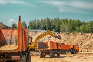 The process of loading sand in a sand quarry. Trucks are waiting for cargo.