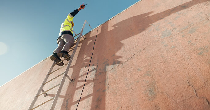 Wall, technician and low angle of man on ladder for installation, safety and outdoor construction. Climb, radio or cable contractor on steps for electrical check, communication and building space