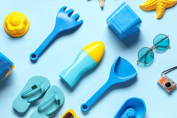 Composition with bottle of sunscreen cream, sand beach molds and accessories on blue background,...