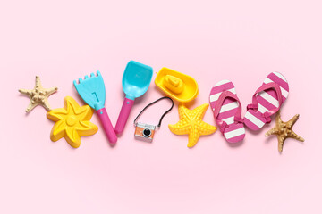 Composition with beach sand molds, starfishes and beach accessories for children on pink background