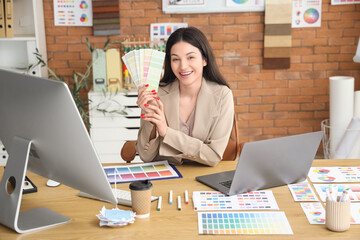 Beautiful designer with color palettes at table in office